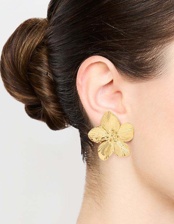 Showcasing waterproof gold plated stainless steel textured flower stud earrings with floral design on ear view