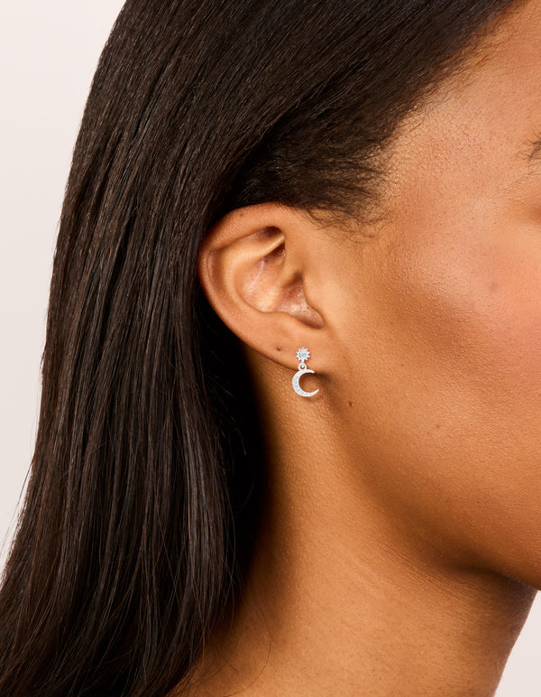 Showcasing sterling silver cubic zirconia drop stud earrings with celestial moon design in dainty style on ear view