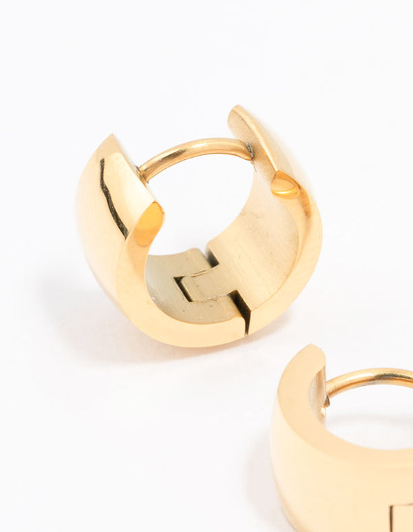 Featuring waterproof gold plated stainless steel huggie hoop earrings with clasp mechanism close up view