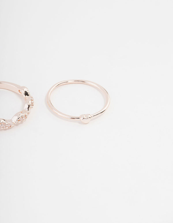 Highlighting rose gold plated rings with mini bow and heart accents featuring cubic zirconia in a 3-pack close up view