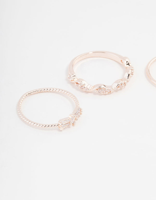 Highlighting rose gold plated rings with mini bow and heart accents featuring cubic zirconia in a 3-pack close up view
