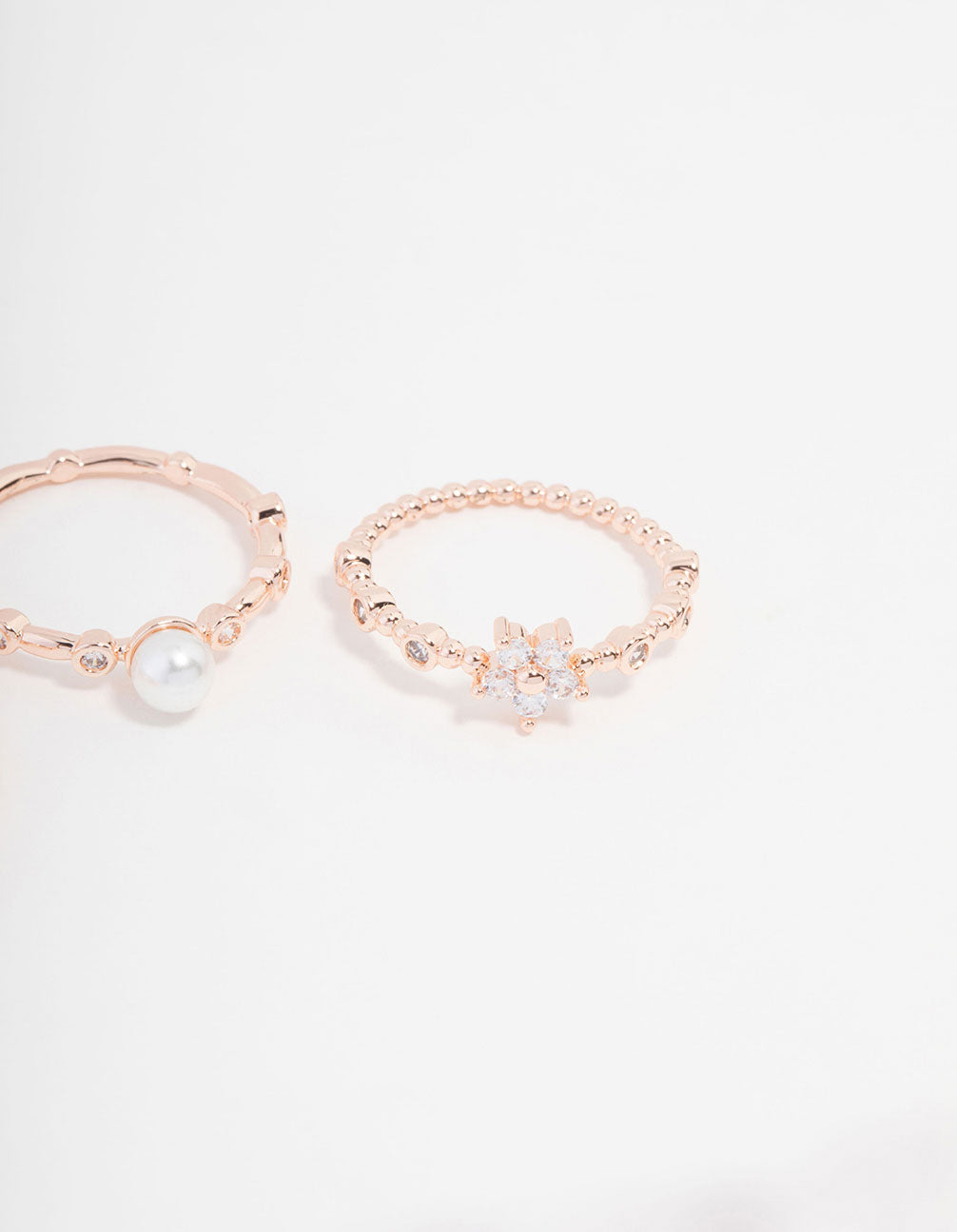 Showcasing rose gold plated cubic zirconia pearl bamboo ring in a 3-pack with floral design and dainty styling close up view
