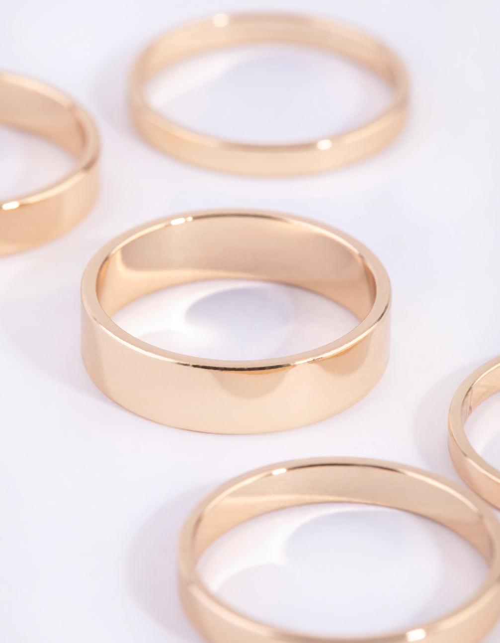 Featuring gold flat band rings in 4-pack close up view