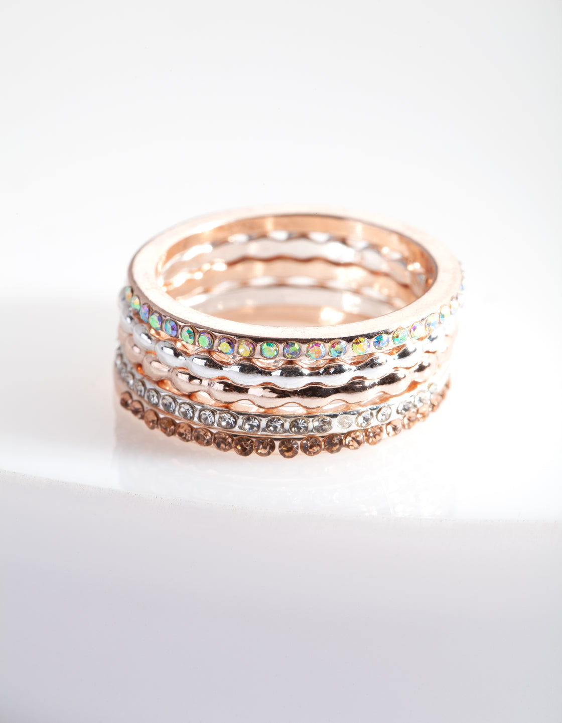 Showcasing a mixed metal fine diamante ring 5-pack in silver, gold, and rosy brown tones front view