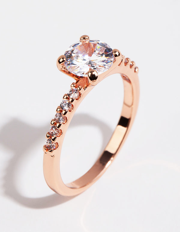 Showcasing a rose gold plated cubic zirconia round band ring with prong setting and pavé accents side detail view