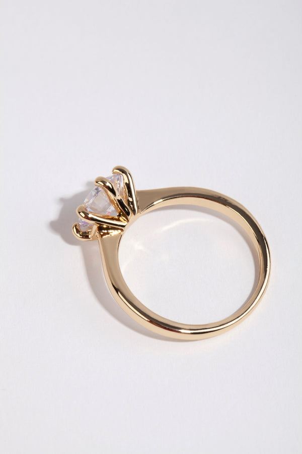 Crafted from gold plated material this round cubic zirconia ring highlights clear stone detailing side detail view