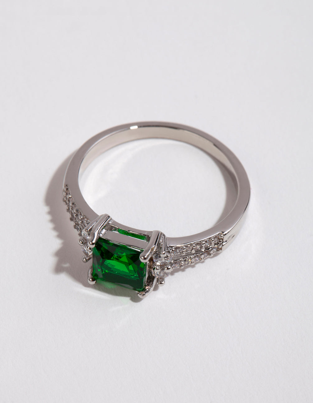 Featuring a silver square emerald cubic zirconia ring with green stone and pavé accents close up view