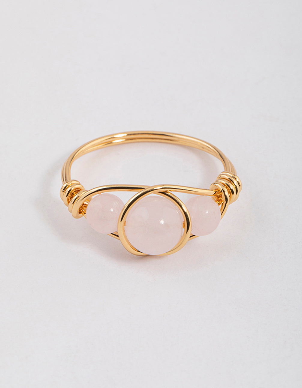 Offering a gold plated wrapped triple stone ring featuring beads with statement design close up view