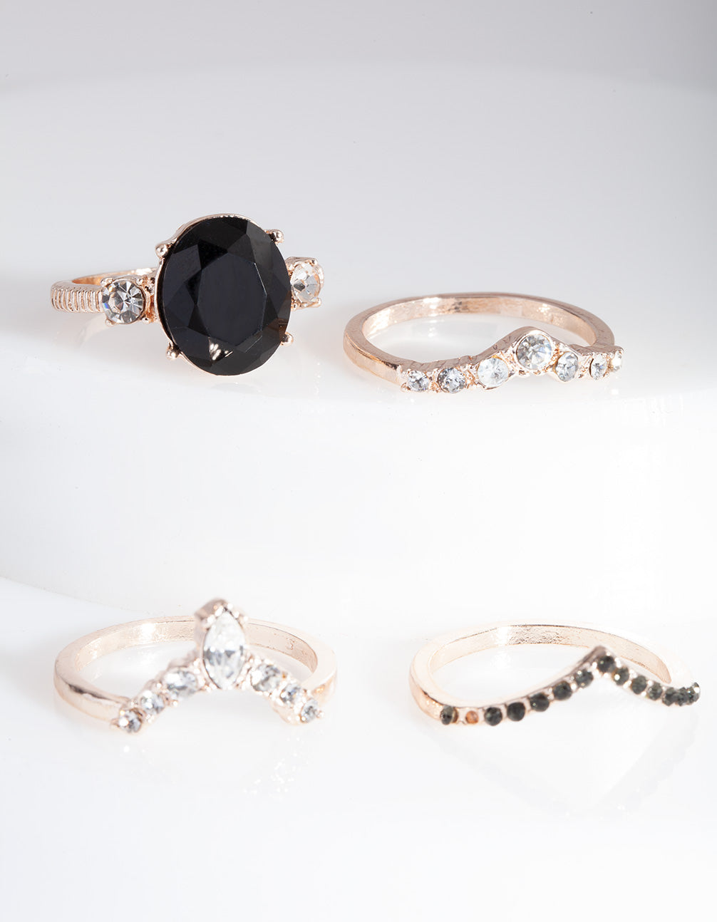 Introducing a rose gold black stone ring stack featuring statement styling front view