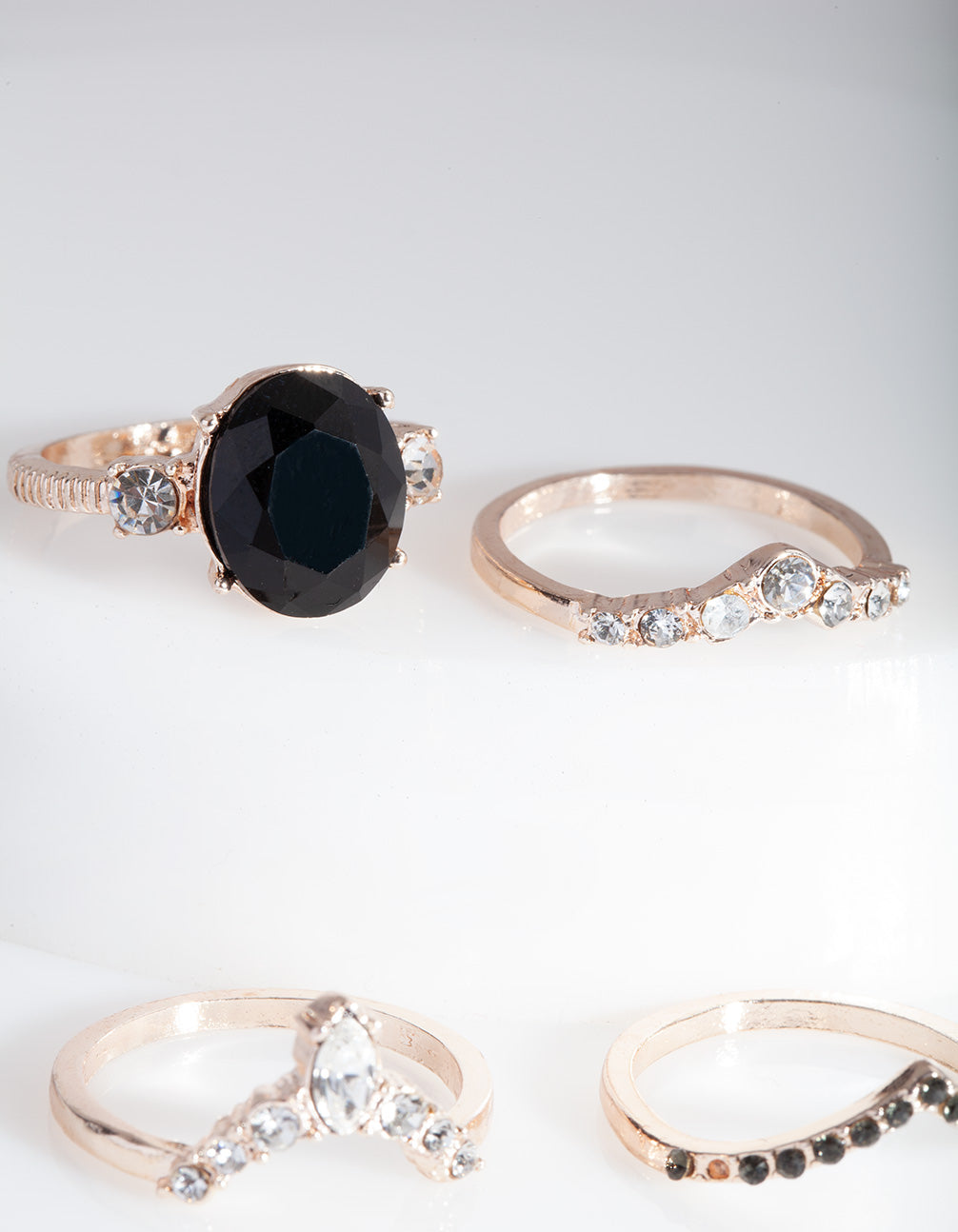 Showcasing rose gold black stone ring stack with statement design side detail view
