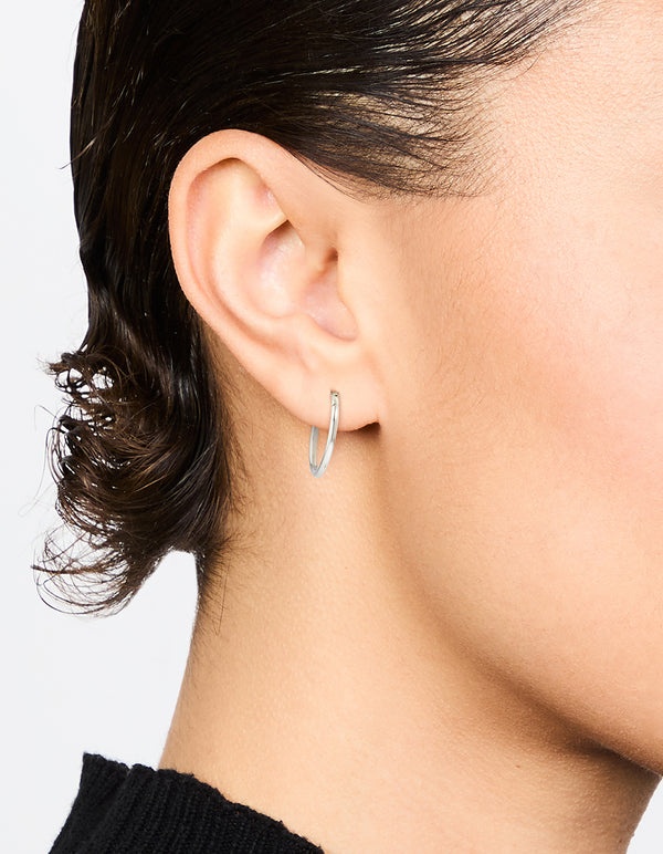 Featuring waterproof stainless steel sleeper earrings in silver, 12 MM size on ear view