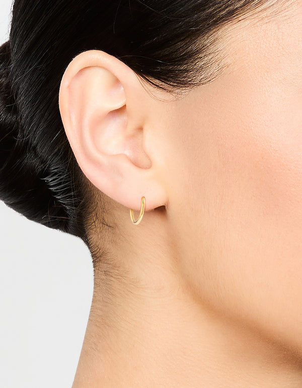 Showcasing waterproof gold plated stainless steel sleeper earrings in 10 MM with hoop closure on ear view