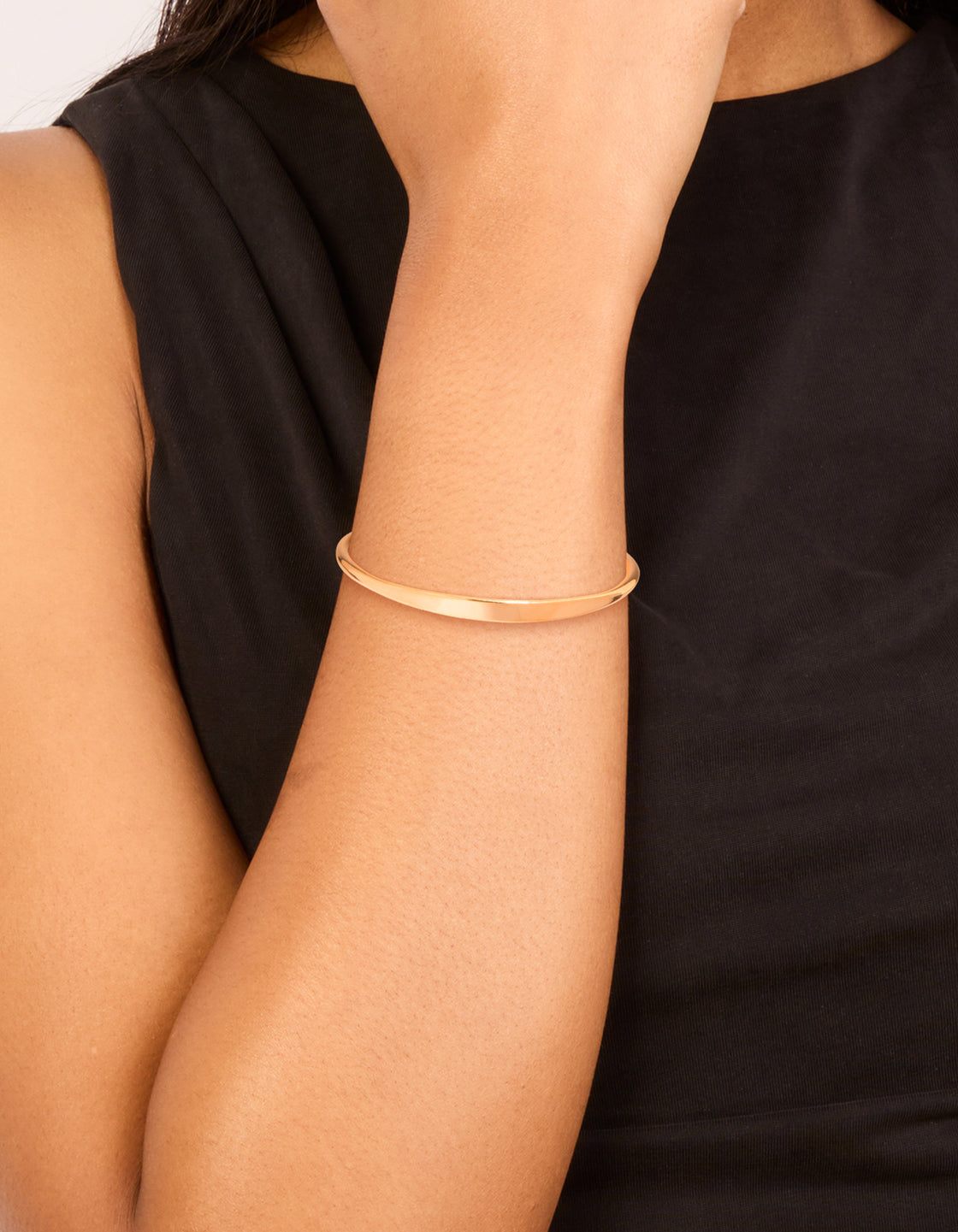 Showcasing a waterproof gold plated stainless steel slim wrist cuff bangle in gold on wrist view