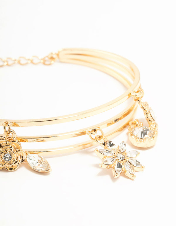 A wrist cuff with floral charm design in gold close up view