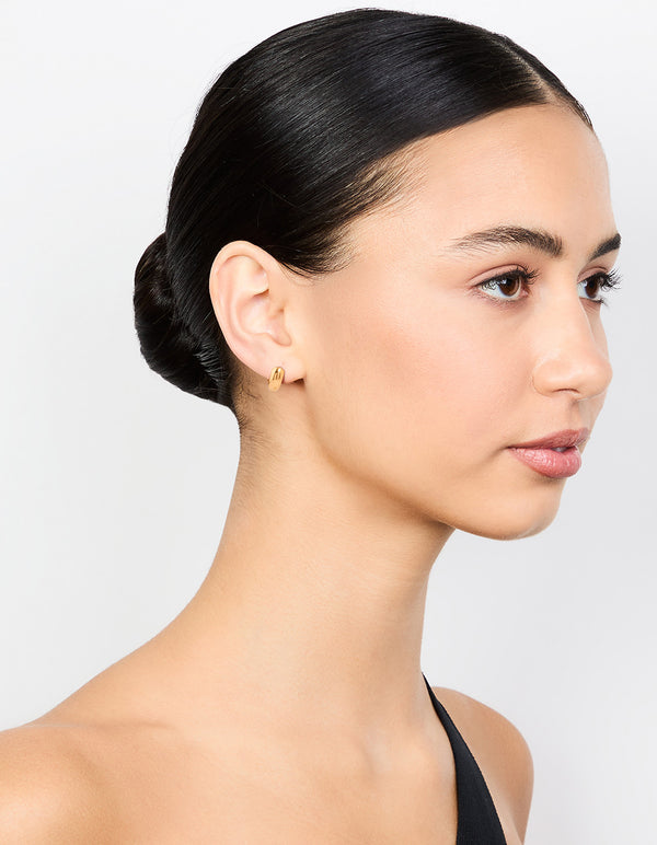 Designed with waterproof gold plated stainless steel chubby huggie earrings featuring closure on model view