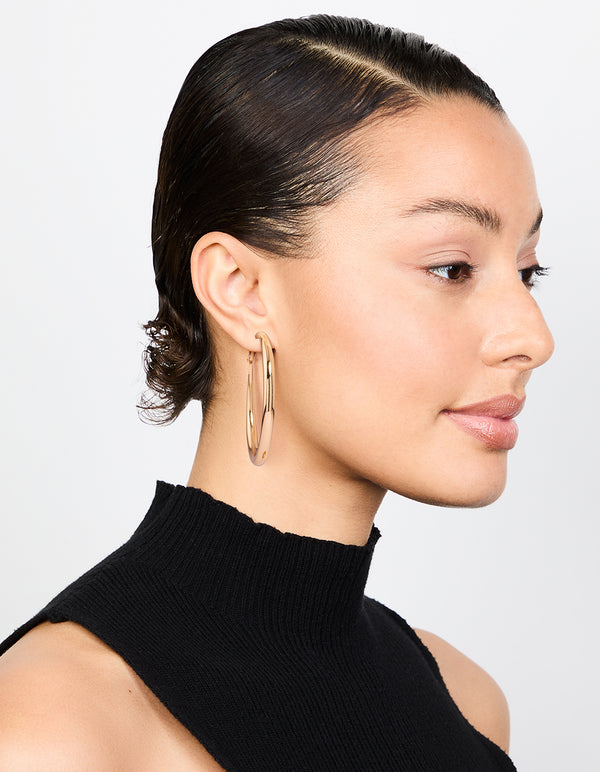 Crafted with gold dome hoop earrings with closure in a polished finish on model view