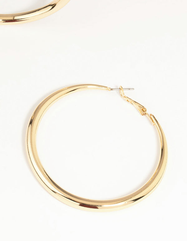 Highlighting gold dome hoop earrings with closure and fastening mechanism close up view