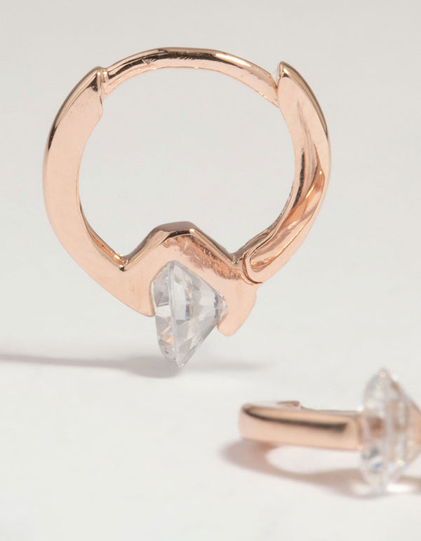 Highlighting rose gold plated sterling silver cubic zirconia huggie earrings with round stone cut close up view