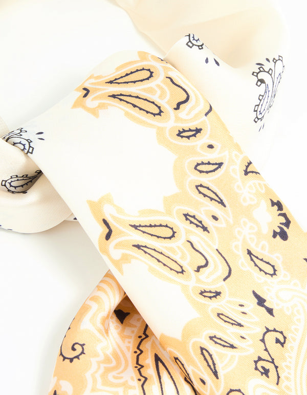 Showcasing a white fabric western scarf featuring paisley print in ivory, khaki, black, and wheat side view