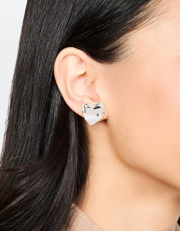 Featuring waterproof stainless steel molten heart stud earrings in dainty silver design on ear view