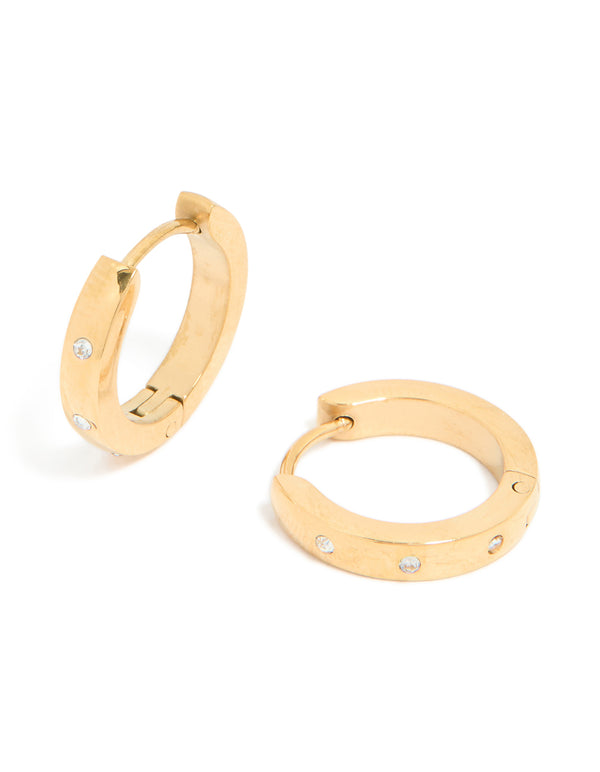 Featuring waterproof gold plated stainless steel cubic zirconia trio huggie earrings with clear details front view
