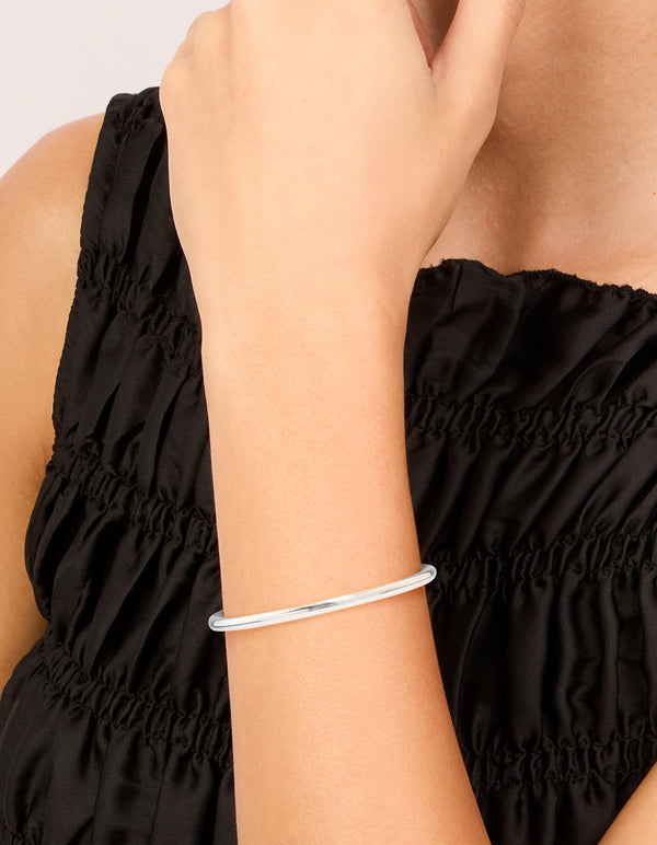 Showcasing a waterproof stainless steel simple hinged bangle in silver on wrist view