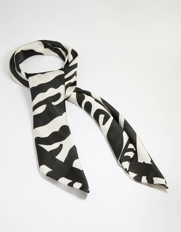 Showcasing a zebra print fabric scarf in black and white with statement styling front view