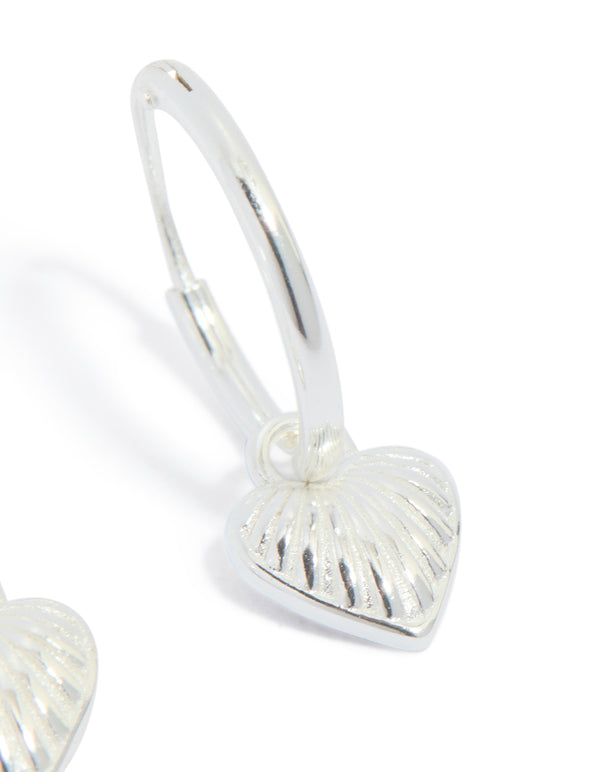 Presenting sterling silver heart huggie earrings in silver post detail view