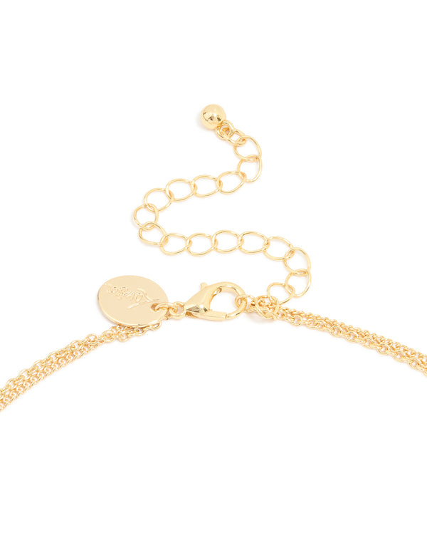 Highlighting a layered necklace featuring cross and letter K charms in gold plated material with cubic zirconia and statement style clasp detail view