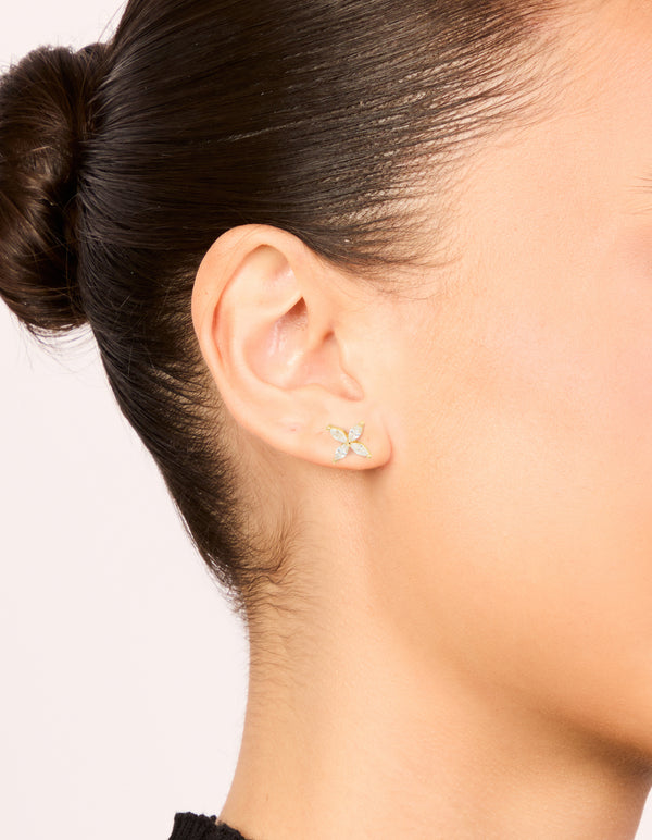 Showcasing waterproof floral stainless steel stud earrings with cubic zirconia in gold plated finish and clear accents on ear view