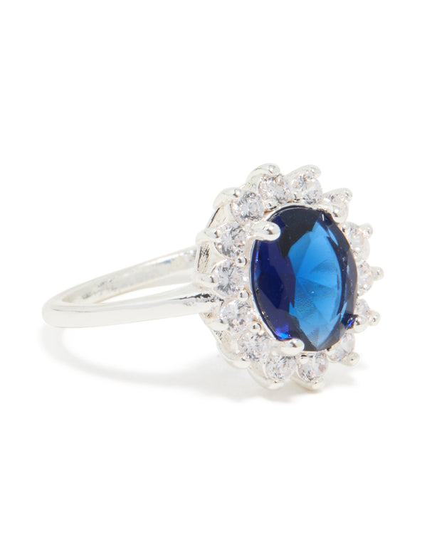 This statement ring features plated material with cubic zirconia border surrounding an oval cut center stone in deep blue side detail view