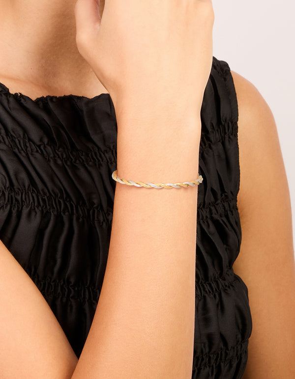 Elegant waterproof twist detail open wrist cuff crafted from gold plated stainless steel in silver tones on wrist view