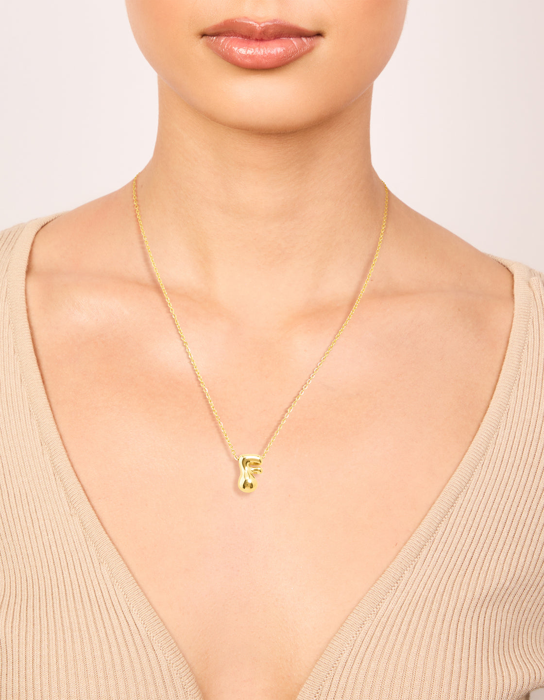 Showcasing a bubble letter F initial pendant necklace featuring waterproof gold plated stainless steel dainty style on neck view