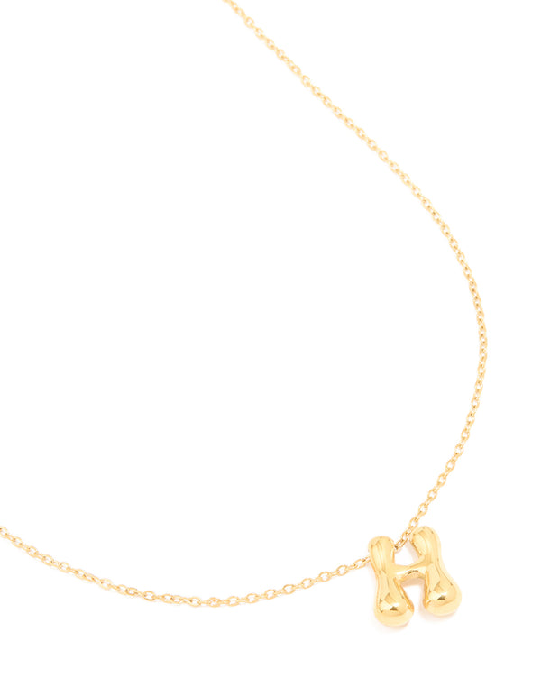 Showcasing a waterproof gold plated stainless steel bubble letter H initial pendant necklace close up view