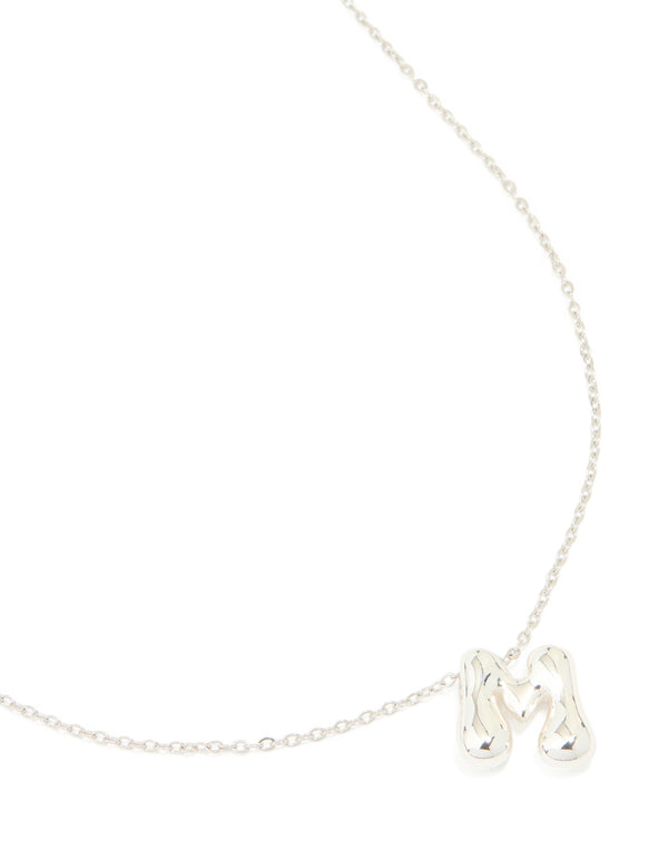 Showcasing a waterproof stainless steel dainty initial pendant necklace with large bubble letter M in silver close up view