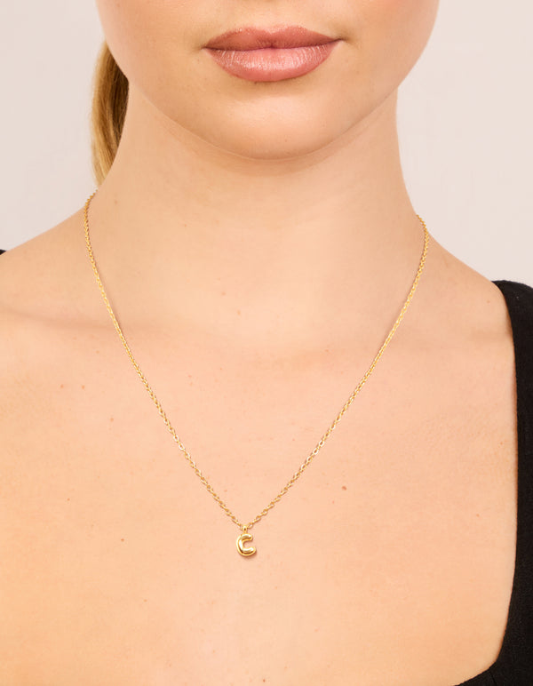 Showcasing waterproof gold plated stainless steel, this mini bubble letter C initial pendant necklace on neck view