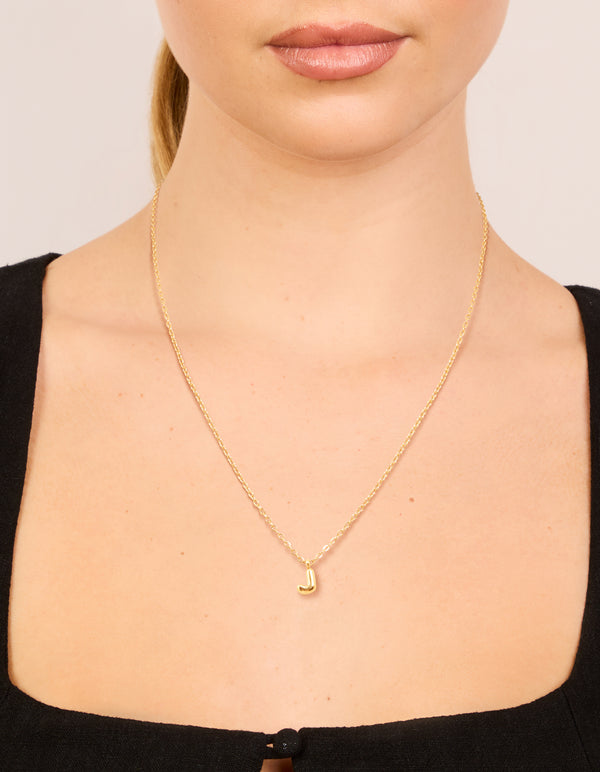 Beautifully designed waterproof mini bubble letter J necklace made from gold plated stainless steel in a dainty style on neck view