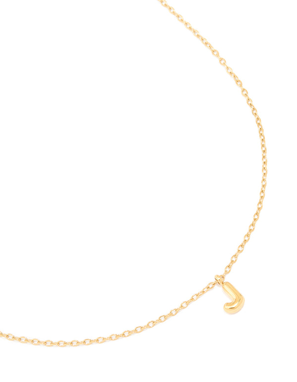 Showcasing a waterproof mini bubble letter J necklace crafted from gold plated stainless steel in a dainty style close up view