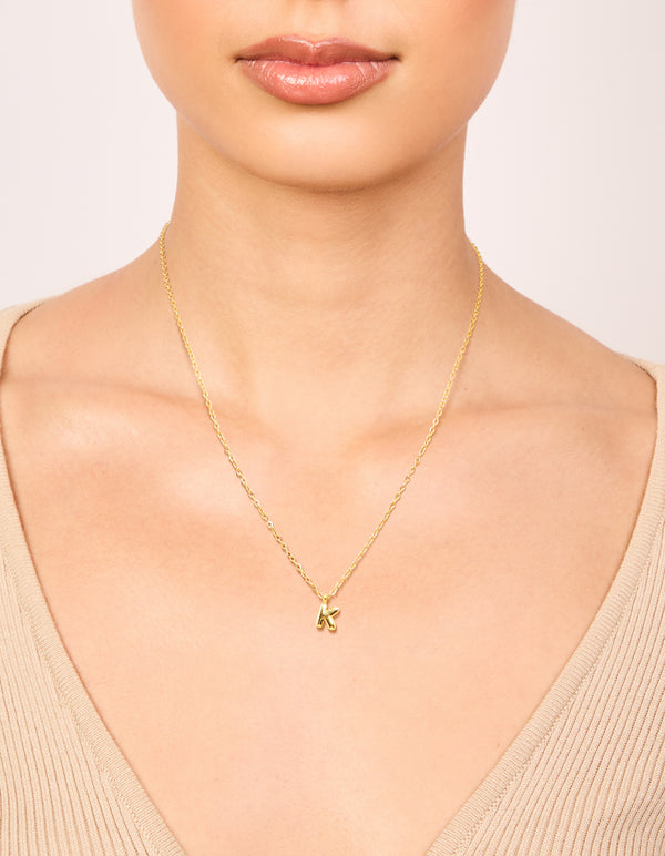 Discover this waterproof mini bubble letter K necklace in gold plated stainless steel with initial pendant on neck view