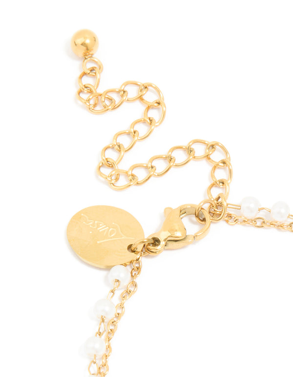 Featuring waterproof gold plated stainless steel, pearl, and cubic zirconia bracelet closure detail view