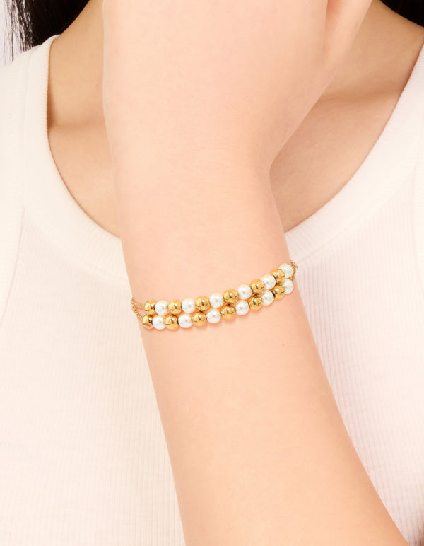 Showcasing a waterproof gold plated stainless steel pearl and ball layered bracelet on wrist view