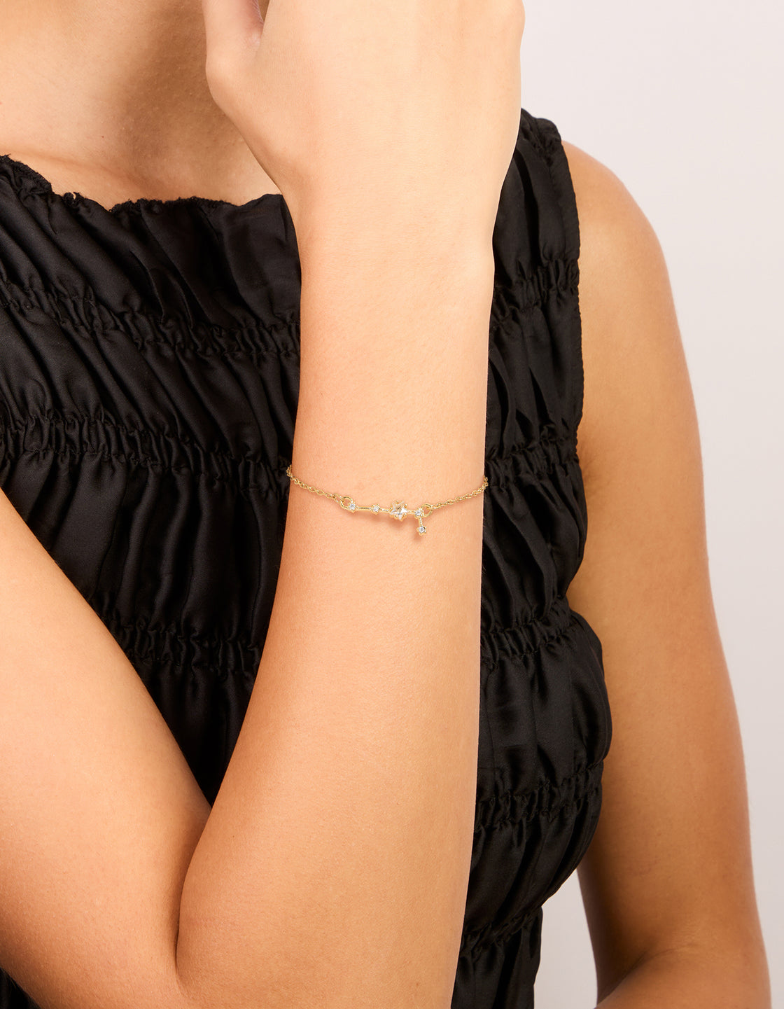 Showcasing a waterproof celestial bracelet crafted from gold plated stainless steel with cubic zirconia and star sign detailing in gold on wrist view