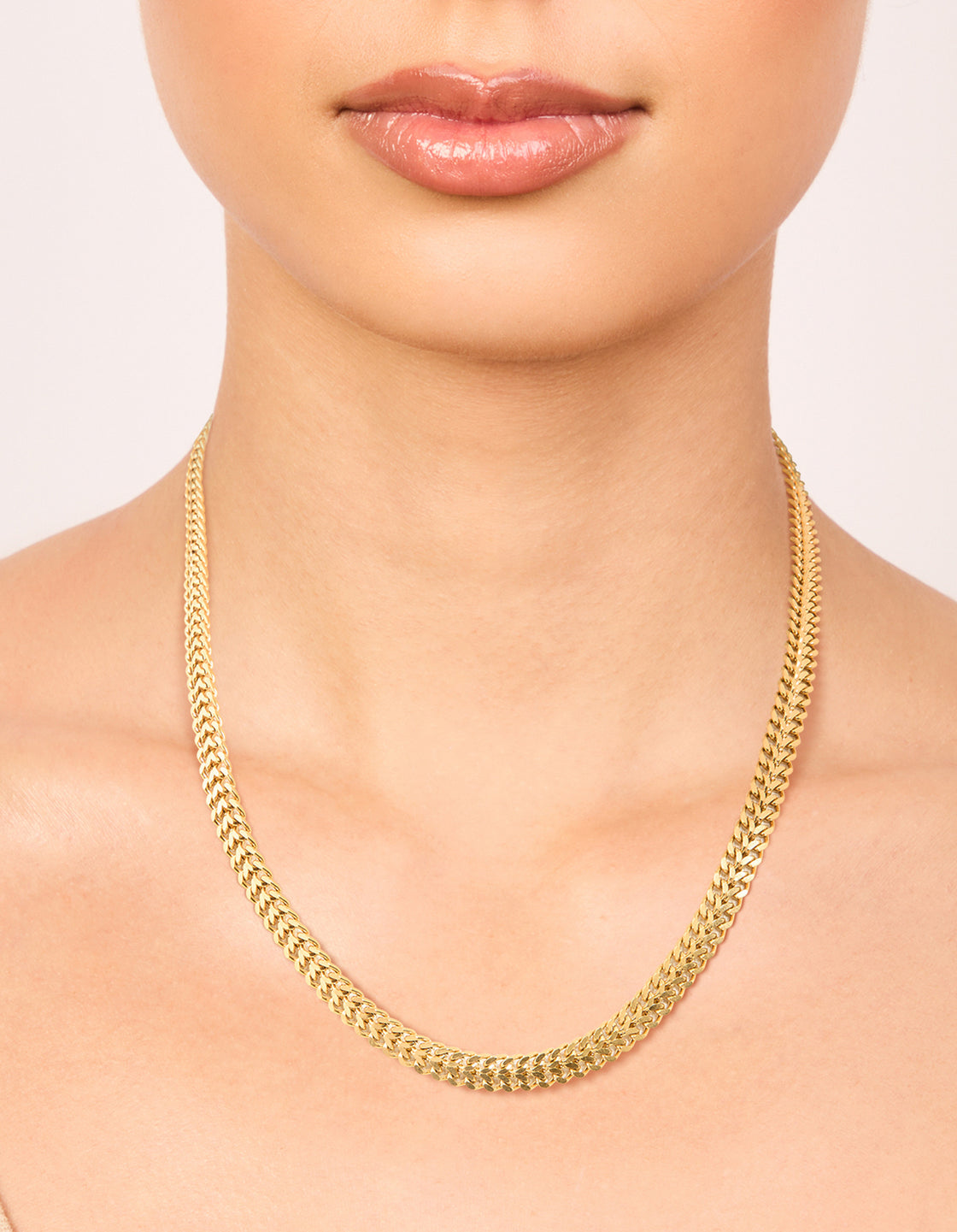 Beautifully designed waterproof chain necklace in gold plated stainless steel featuring flat detail on neck view