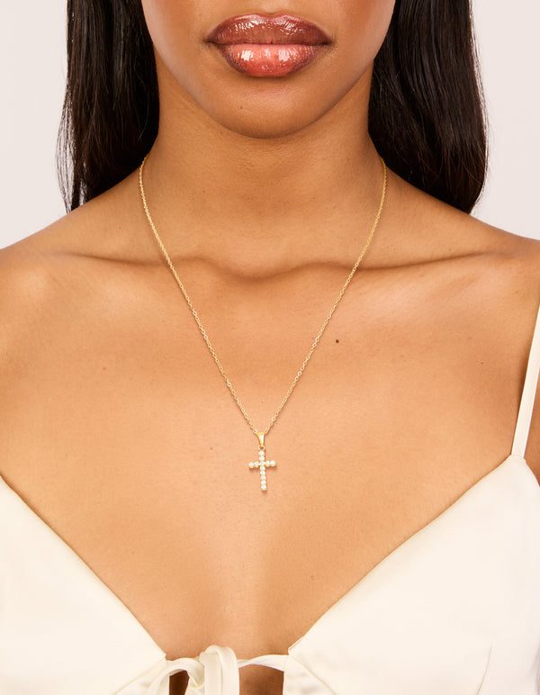 Showcasing a waterproof cross pendant necklace in gold plated stainless steel with cubic zirconia on neck view