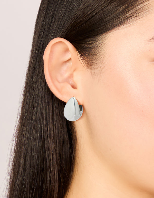 Presenting waterproof stainless steel oval front and back hoop earrings in silver on ear view
