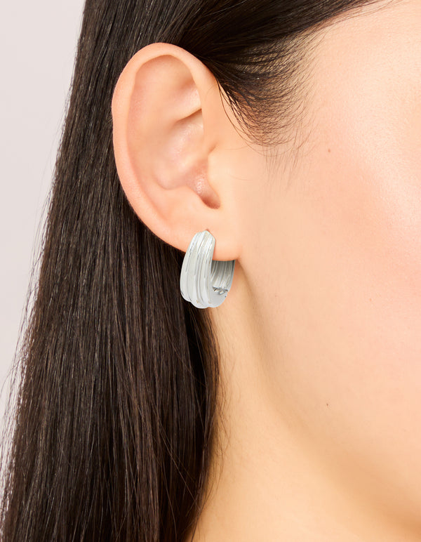 Featuring waterproof stainless steel hinge hoop indented earrings in silver on ear view