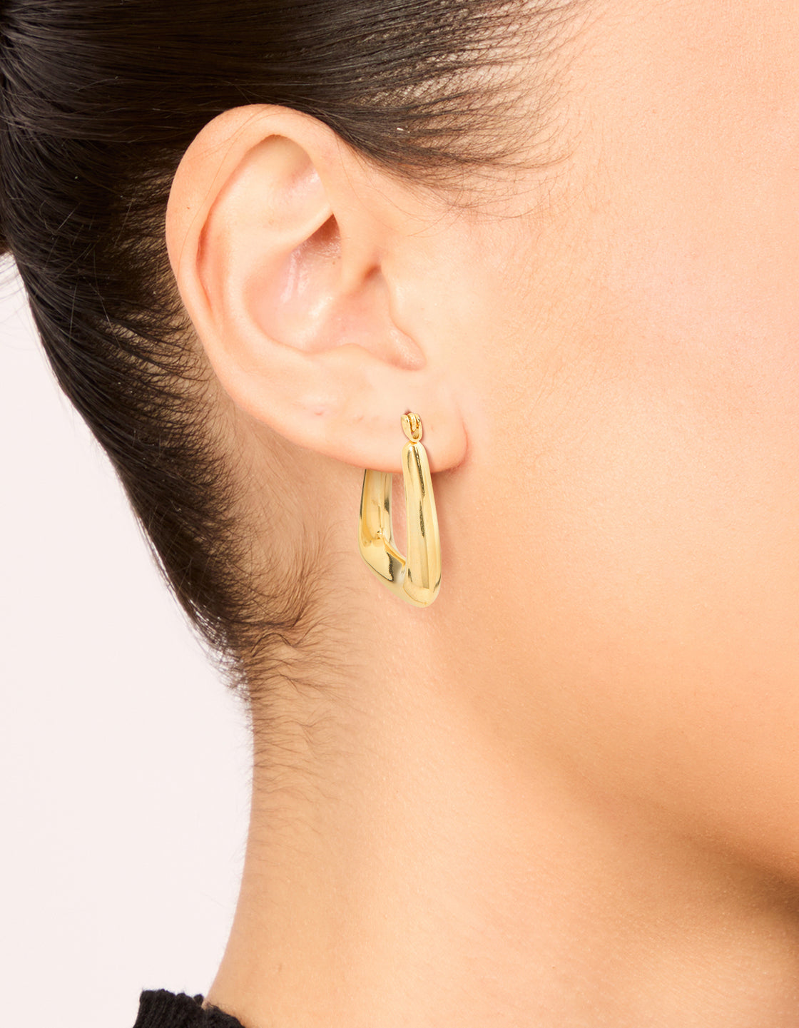 Featuring waterproof gold plated stainless steel trapeze hoop earrings on ear view