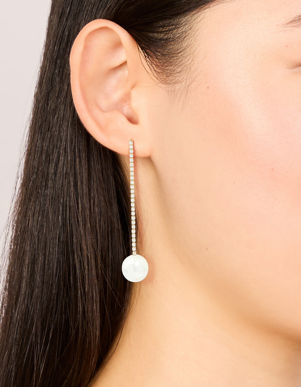 Featuring waterproof gold plated stainless steel drop earrings with pearl and diamante cup chain on ear view