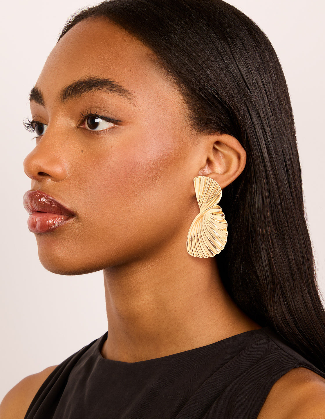 Crafted from waterproof gold plated stainless steel statement flower stud earrings in gold on model view