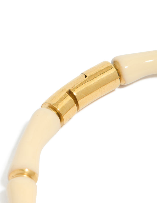 Highlighting the waterproof bamboo white enamel bangle in gold plated stainless steel with ivory closure detail view